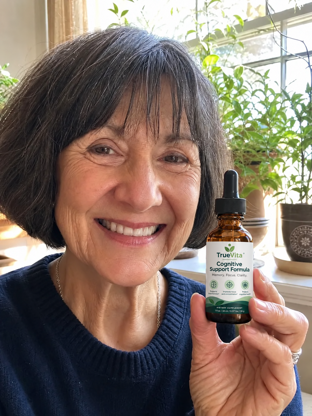 Carol B. smiling and holding her TrueVita bottle